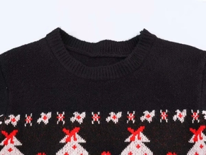Detail van rood en wit kerst jacquard patroon op de halslijn van de zwarte gebreide trui