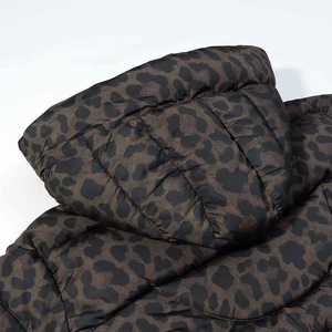 Close-up detail of leopard print hooded puffer jacket showing stitching and texture