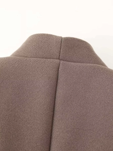 Close-up of premium brown wool coat showing high-quality stitching and fabric texture
