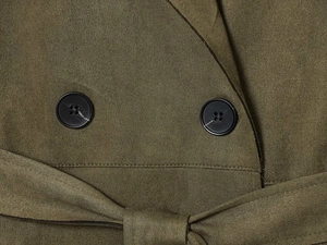 Detail view of olive green faux suede trench coat with matte black buttons and belt texture