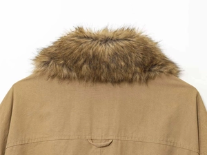 Detailed view of brown faux fur collar and cotton twill fabric on khaki bomber jacket