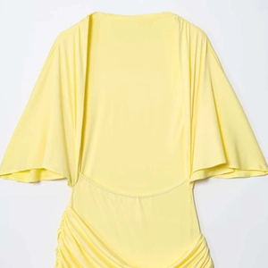 Light yellow backless dress with flared sleeves and stylish ruched detail design
