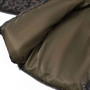 Detail of leopard print puffer jacket with olive green lining and durable metal zipper