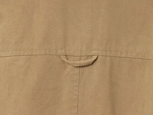 Close-up of khaki flight jacket fabric with locker loop and durable double stitching