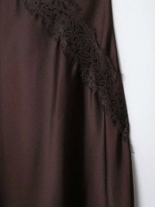 Gros plan sur le tissu en satin marron chocolat avec détails délicats en dentelle noire