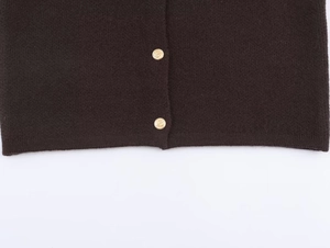 Detailed macro view of dark brown knit fabric hem with embossed gold anchor metal buttons