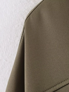 Dettaglio della cucitura della spalla e del tessuto verde oliva scuro del bomber