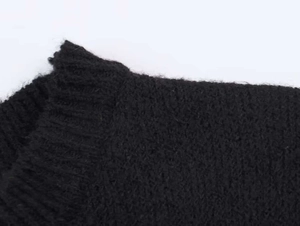 Detail van de zwarte gebreide trui kraag en geribbelde schoudernaden voor de winter