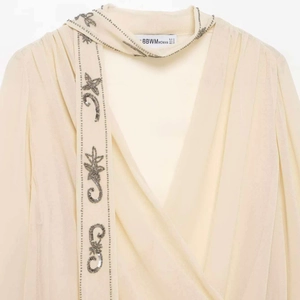 Blouse chic crème à col en V avec broderie d'étoiles en paillettes et liens à nouer