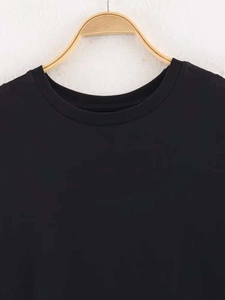 Détail de l'encolure ronde et des coutures sur un t-shirt noir ample pour femme