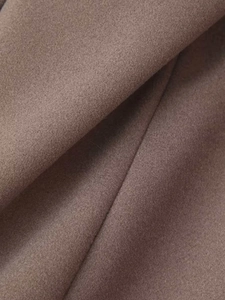Macro shot of khaki wool blend coat fabric showing soft texture and premium material detail