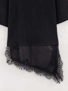 Vue détaillée de l'ourlet asymétrique en satin noir avec dentelle cils délicate