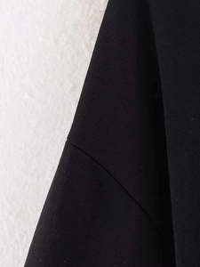 Détail du haut noir avec empiècement en dentelle, coutures soignées et texture du tissu