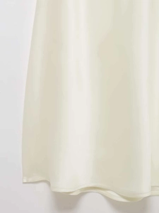 Gros plan détaillé du tissu satiné beige avec un drapé élégant et une finition soignée
