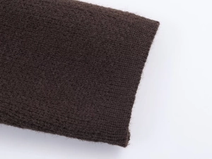 Macro shot of dark brown knit fabric with soft texture and fine stitching detail