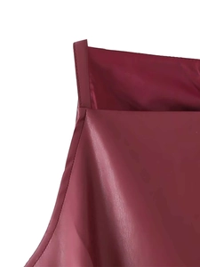 Detail view of burgundy faux leather fabric and stitching on a minimalist plush dress