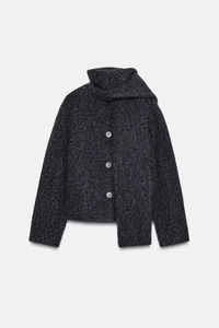 Detail of grey bouclé knit jacket showing scarf collar design and large front buttons