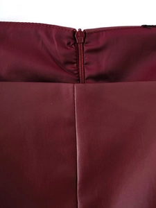 Detail view of the burgundy faux leather dress featuring a seamless invisible zipper closure