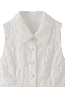 Vue détaillée du tissu jacquard à motifs de feuilles et boutons assortis sur gilet blanc