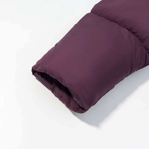 Dettaglio dei polsini elastici antivento su un piumino trapuntato bordeaux per l'inverno