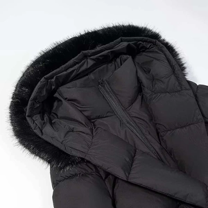 Gros plan détaillé d'un manteau d'hiver noir avec col en fausse fourrure et texture matelassée