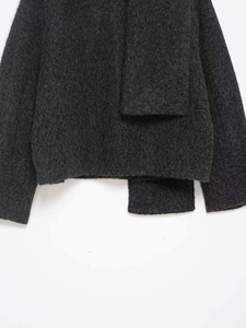 Detail of dark gray knit texture and fuzzy mohair-like fibers on a stylish cropped jacket