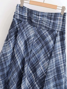 Détail d'une jupe midi à carreaux plissée à taille haute de couleur bleu foncé