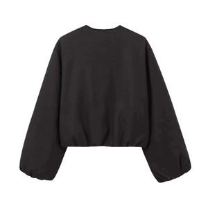 Detail showing the ribbed cuffs and hem of this black vintage bomber jacket with soft texture