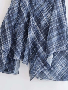 Détail de l'ourlet asymétrique de la jupe midi à carreaux bleus et blancs en tissu léger