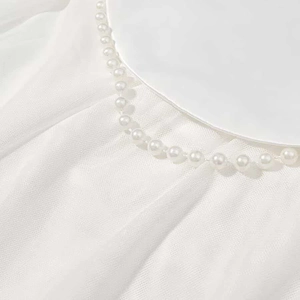 Détail de l'encolure en tulle blanc ornée de perles élégantes pour robe de soirée