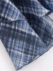 Détail du tissu à carreaux bleu semi-transparent avec une fine couture violette au bord