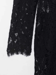 Close-up of black floral lace fabric detailing with intricate hollow-out embroidery patterns