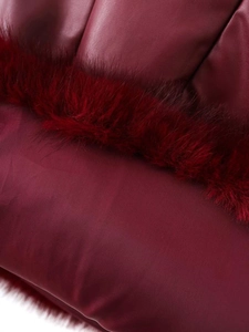 Detail of burgundy leather paneling and plush faux fur trim on a fashion dress