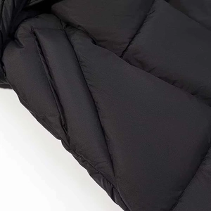 Gros plan d'une doudoune noire matelassée avec tissu coupe-vent et coutures détaillées