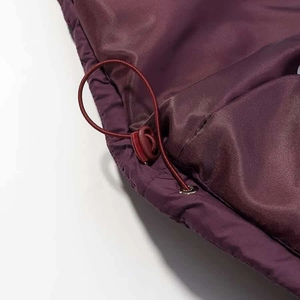 Dettaglio della giacca bordeaux con cordoncino elastico, fermaglio e occhiello metallico