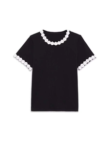 Close-up of contrast floral crochet lace trim on the collar of a black knit sweater
