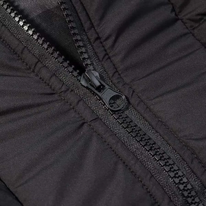 Détail de la fermeture éclair en résine et du tissu en nylon matelassé d'un manteau d'hiver