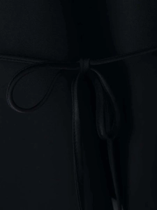Detailaufnahme eines schwarzen Halter-Tops mit dekorativer Schleife aus schlichtem Webstoff