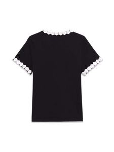 Close-up of the ribbed knit fabric and white floral crochet lace on the black round neckline