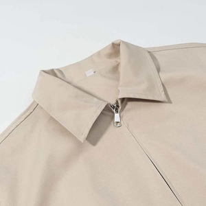 Detail of lapel collar and silver metal zipper on the beige casual summer jacket