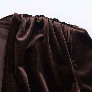 Détail des fronces sur l'épaule d'une robe en velours marron foncé à reflets doux