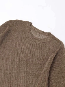 Detail of round neckline and textured mesh knit fabric on a brown loose summer sweater