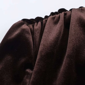 Gros plan détaillé du tissu en velours marron foncé montrant une texture raffinée