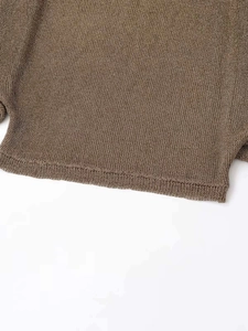 Close-up of brown knit fabric showing intricate mesh texture and fine edge stitching