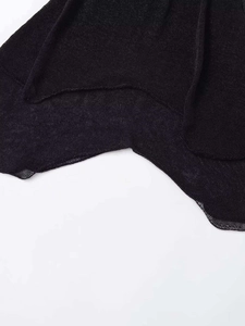 Vista macro di inserti in rete e orlo in maglia asimmetrico su vestito nero