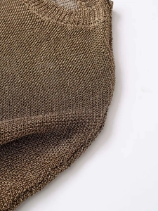 Close-up of metallic bronze knitted fabric with a sheer mesh texture and gold luster