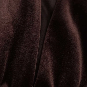Détail du tissu en velours marron foncé montrant la texture riche et les finitions soignées