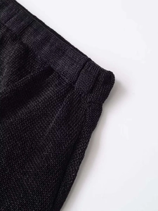 Dettaglio della vita elastica e della trama in maglia dell'abito nero con rete