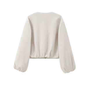 Detail of oat beige bomber jacket featuring dropped shoulders and elastic hemline