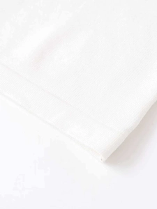 Close-up detail of high-density white knitted fabric showing precise stitching on short sleeve